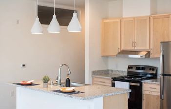 A kitchen with a black stove top oven and a white sink.